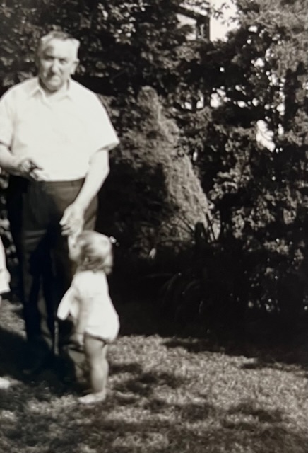 Schwarz weiß Foto mit altem Mann und Zigarre. An seiner anderen Hand hält er die Hand eines kleinen Kindes mit blonden Haaren.